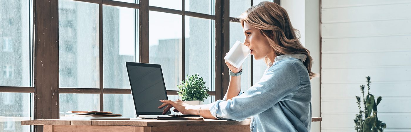 Vrouw aan het werk in haar thuiskantoor achter haar computer met Xerox® Docushare® Go oplossing