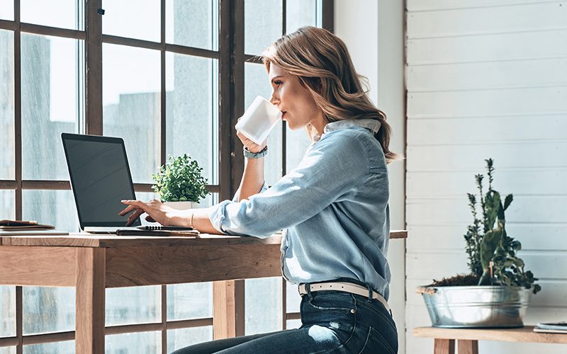 Mulher que trabalha no escritório em casa no seu computador com a solução Xerox® Docushare® Go