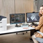Vrouw in een kantoor naast de Xerox® VersaLink® C620 printer