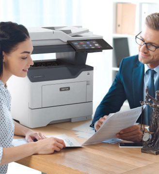 Um homem e uma mulher sentados a uma secretária, a conversar enquanto uma impressora Xerox® está posicionada nas proximidades. Um homem e uma mulher sentados a uma secretária, a conversar enquanto uma impressora Xerox® está posicionada nas proximidades.