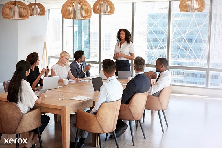 Une femme se tient devant un groupe, présentant avec assurance son sujet et interagissant avec le public pendant la session. Une femme se tient devant un groupe, présentant avec assurance son sujet et interagissant avec le public pendant la session.